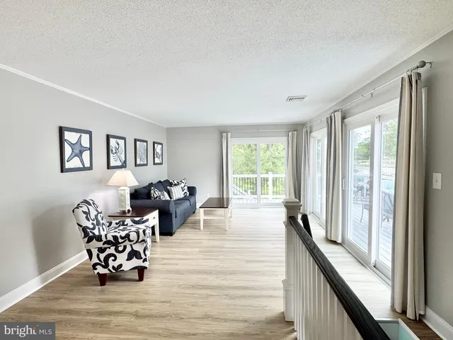 a white kitchen with stainless steel appliances granite countertop a stove a sink dishwasher a refrigerator and a microwave