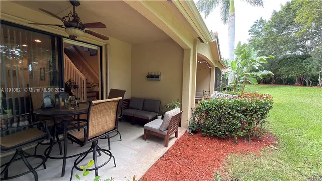 a view of a chairs and table in patio with yard