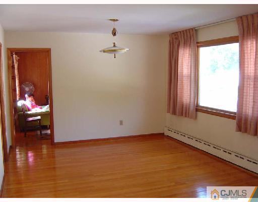 888 Hermann Road North Brunswick, NJ 08902 - Photo 5 of 10 a view of an empty room with wooden floor and a window