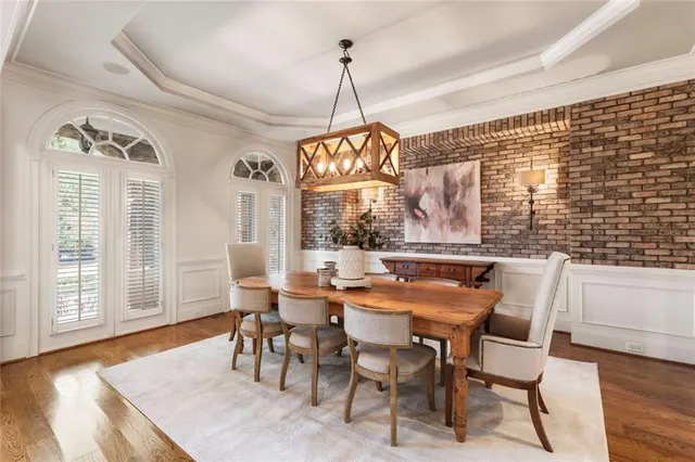a dining room with furniture a chandelier and wooden floor