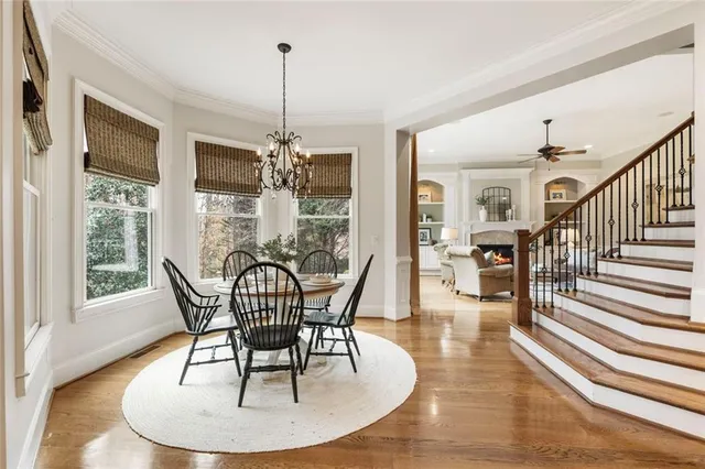 a dining room with furniture a chandelier and wooden floor