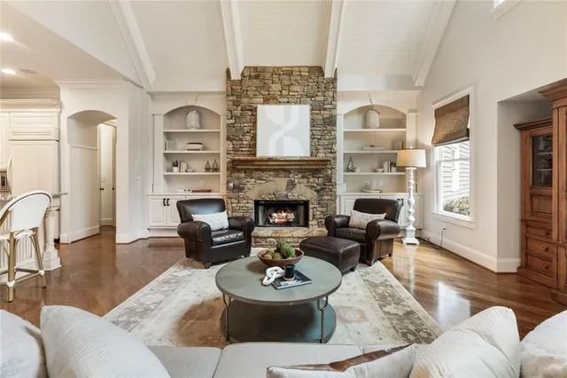 a living room with furniture a fireplace a rug and wooden floor