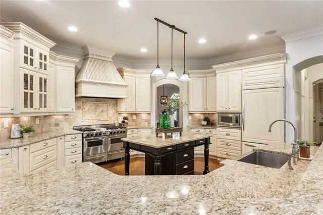 a kitchen with stainless steel appliances granite countertop a stove a sink and a refrigerator