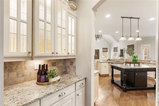 a kitchen with stainless steel appliances granite countertop a stove a sink and white cabinets