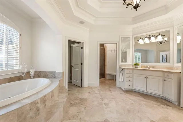 a spacious bathroom with a tub sink and mirror