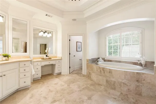 a spacious bathroom with a tub sink and mirror
