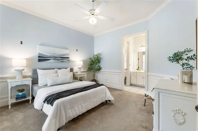 a bedroom with a large bed and a chandelier