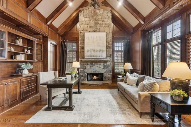 a living room with furniture a fireplace and a large window