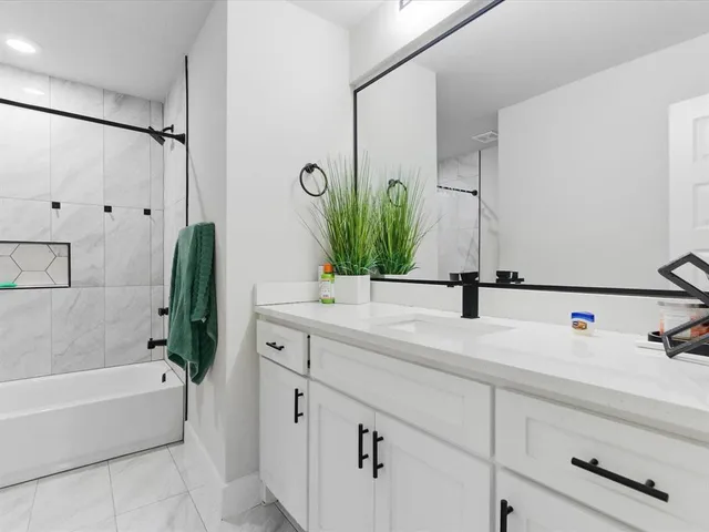 a bathroom with a bathtub sink and mirror