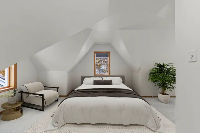 a bedroom with a bed and a potted plant