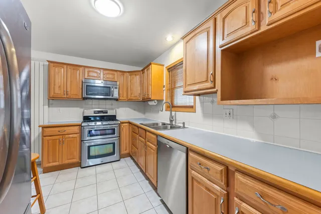 a kitchen with stainless steel appliances granite countertop a sink dishwasher stove and refrigerator