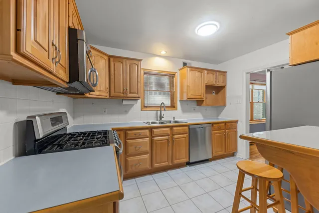 a kitchen with stainless steel appliances granite countertop a sink a stove counter space and cabinets