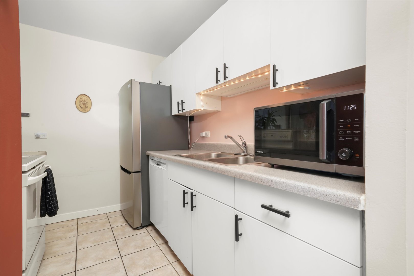 5320 North Sheridan Road, Unit 2304 Chicago, IL 60640 - Photo 6 of 28 a kitchen with stainless steel appliances a sink and a refrigerator