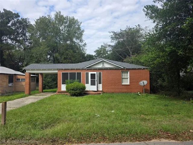 a front view of a house with a yard and trees