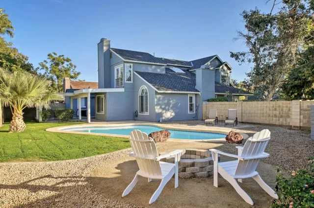a dining room with wooden floor a chandelier a wooden table and chairs