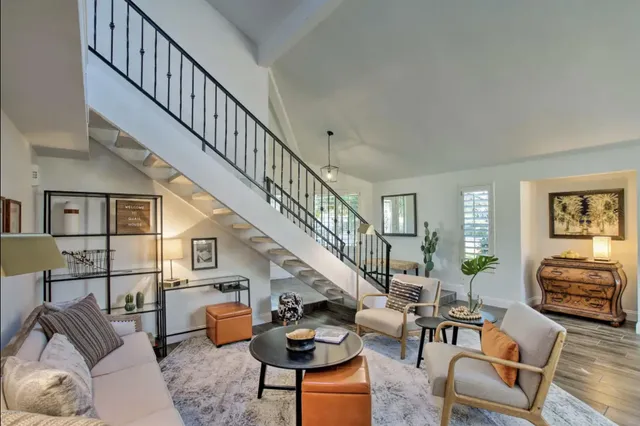 a living room with furniture a dining table and wooden floor
