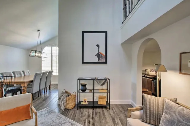 a dining room with wooden floor a chandelier a wooden table and chairs
