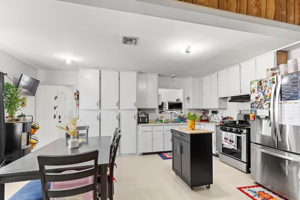 a kitchen with white cabinets and stainless steel appliances