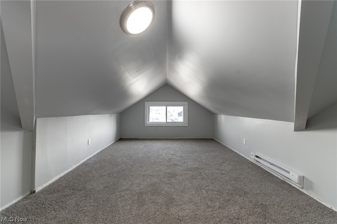 1228 Melbourne Road Cleveland, OH 44112 - Photo 26 of 35 Bonus room featuring lofted ceiling, carpet, and a baseboard heating unit