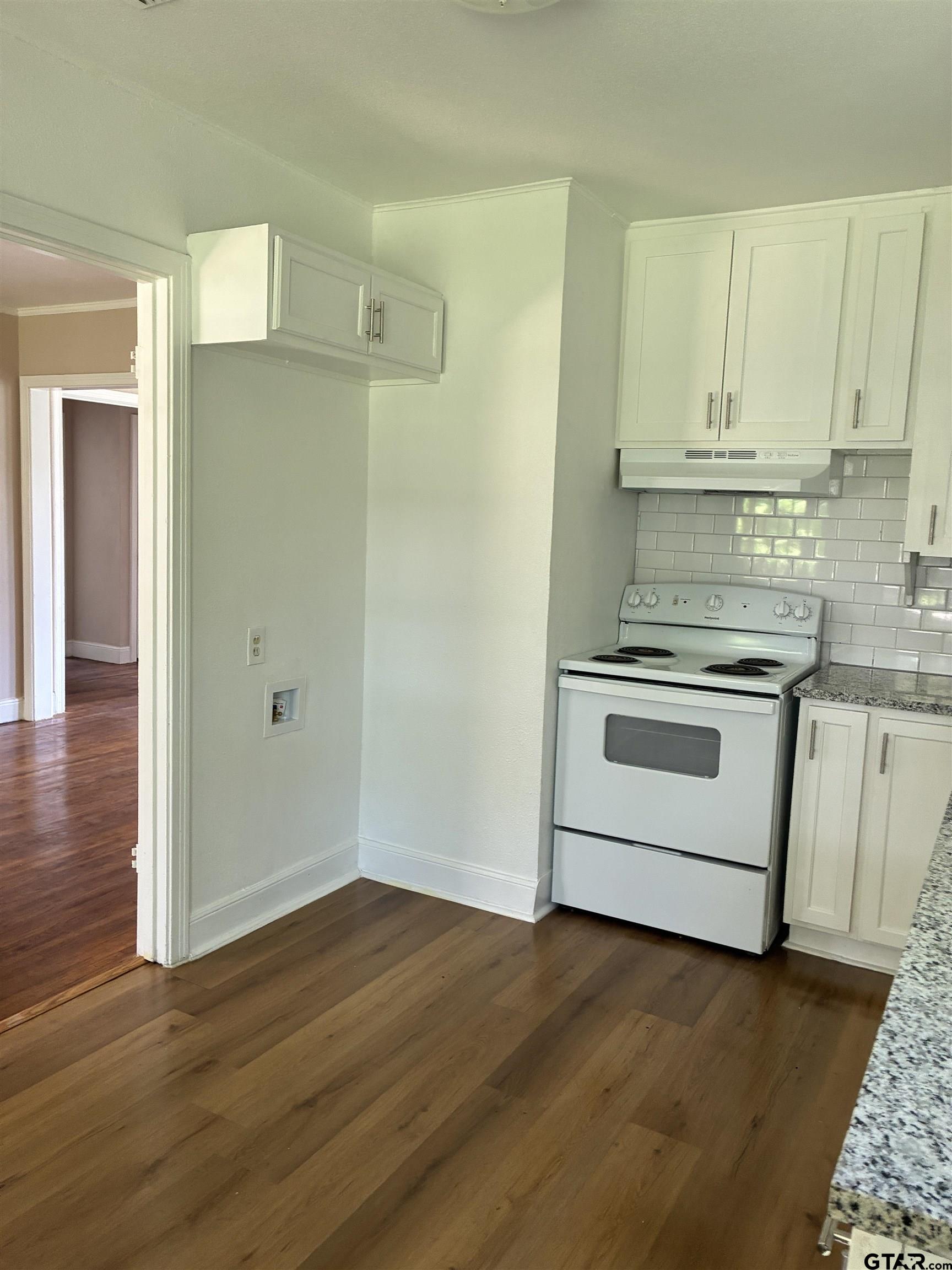 811 West 5th Street Tyler, TX 75701 - Photo 9 of 26 a kitchen with granite countertop white cabinets and stainless steel appliances