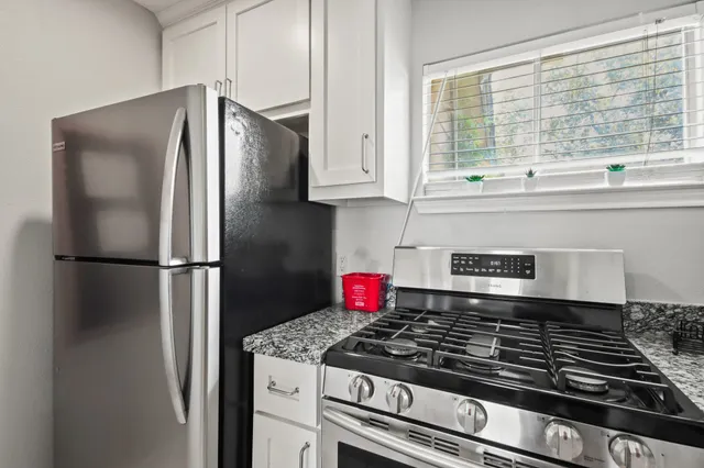 a kitchen with stainless steel appliances granite countertop a refrigerator and a stove