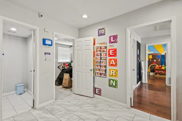 a view of a hallway with wooden floor and furniture