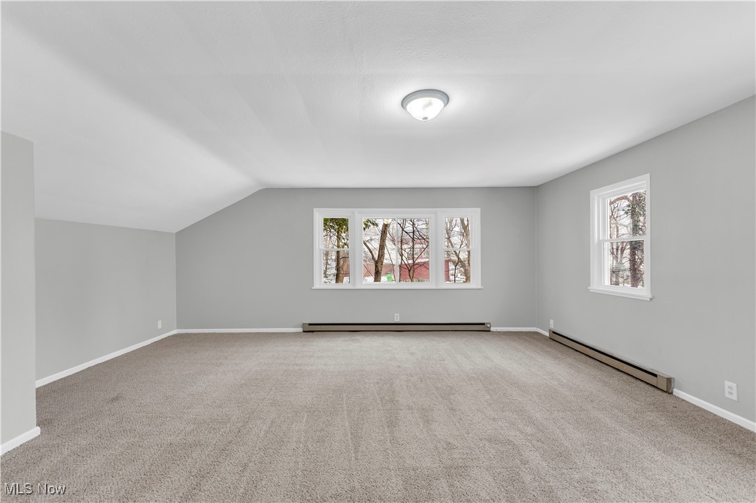 4693 Liberty Road South Euclid, OH 44121 - Photo 16 of 33 Additional living space with baseboard heating, light colored carpet, healthy amount of natural light, and vaulted ceiling
