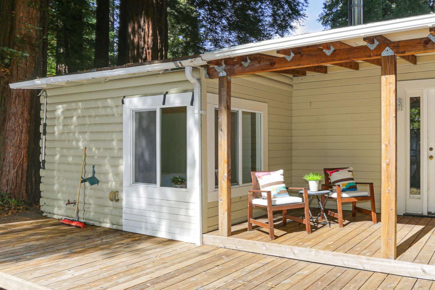136 Pool Drive Boulder Creek, CA 95006 - Photo 22 of 25 a view of a patio with table and chairs with wooden floor and fence