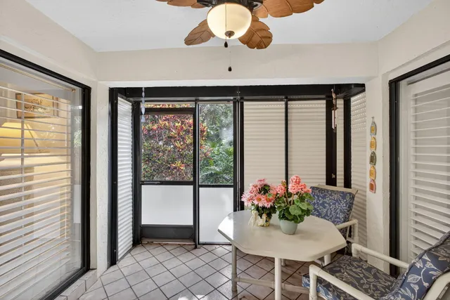 a view of a backyard with chairs potted plants