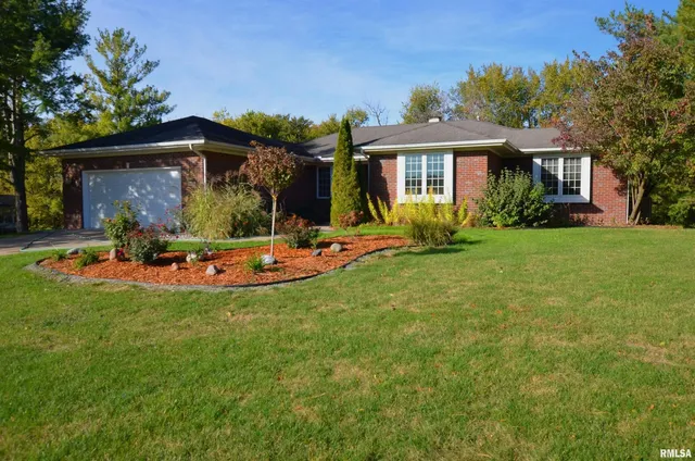 a view of a house with a yard patio and fire pit
