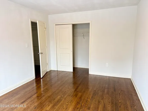 an empty room with wooden floor and closet