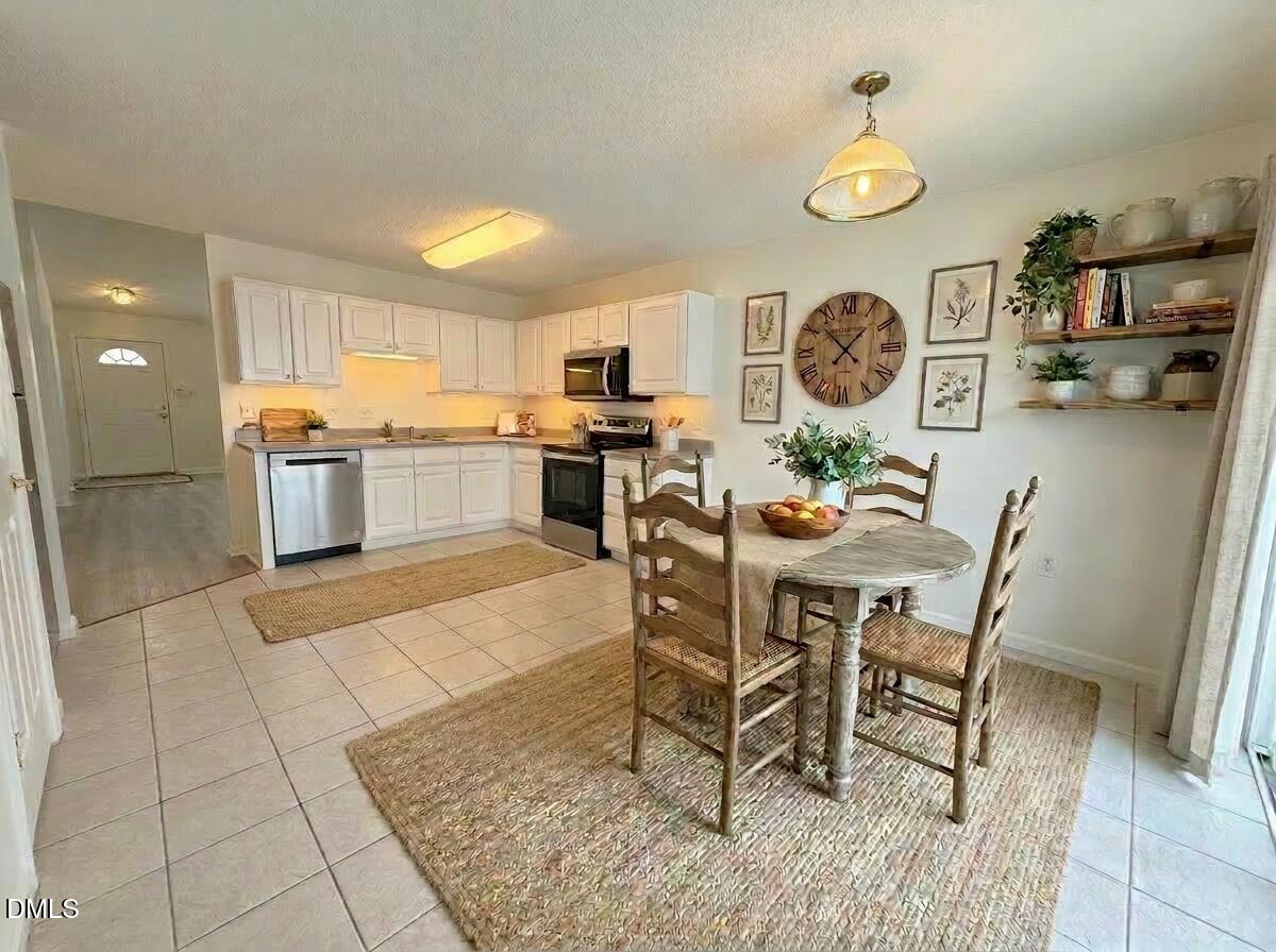 11381 Involute Place, Unit 103 Raleigh, NC 27617 - Photo 10 of 25 a kitchen with a dining table and chairs