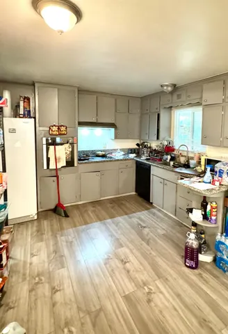 a kitchen with stainless steel appliances a stove top oven a sink dishwasher and cabinets with wooden floor