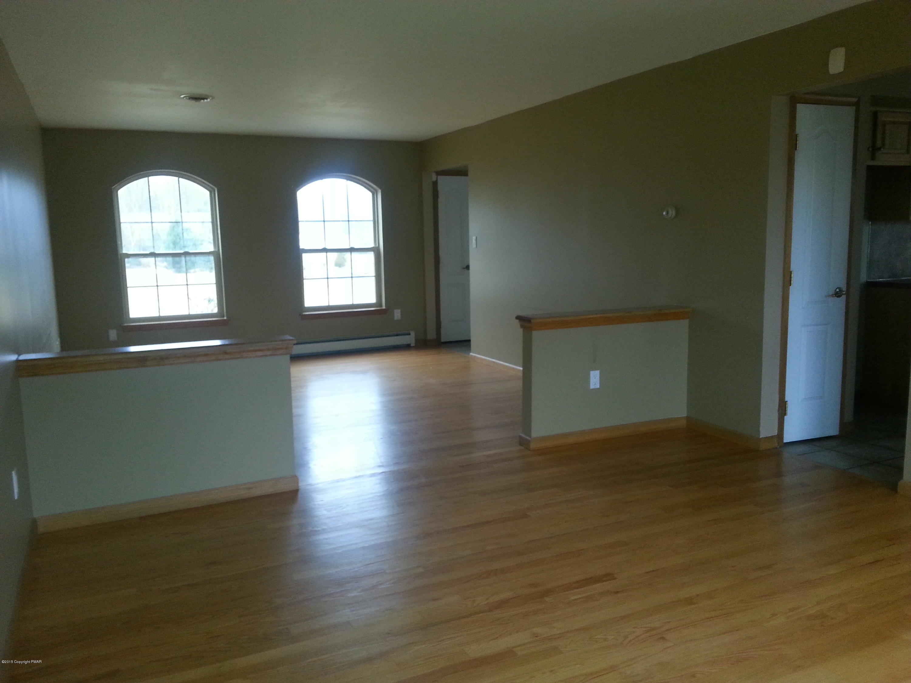 180 Anna Road Blakeslee, PA 18610 - Photo 15 of 26 an empty room with wooden floor and windows