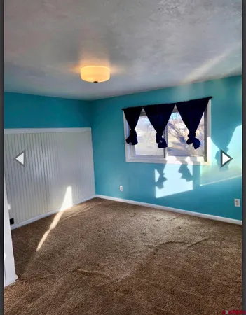 a view of a big room with wooden floor and windows