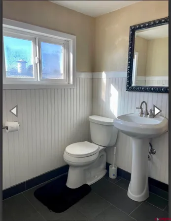 a bathroom with a sink toilet and mirror