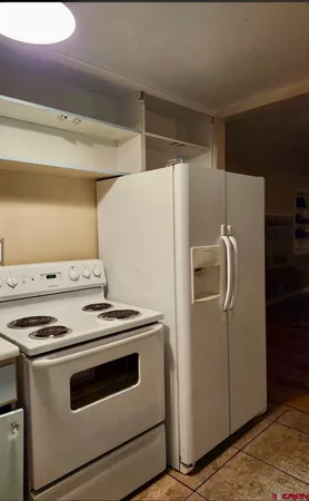 a white refrigerator freezer and a stove sitting inside of a kitchen