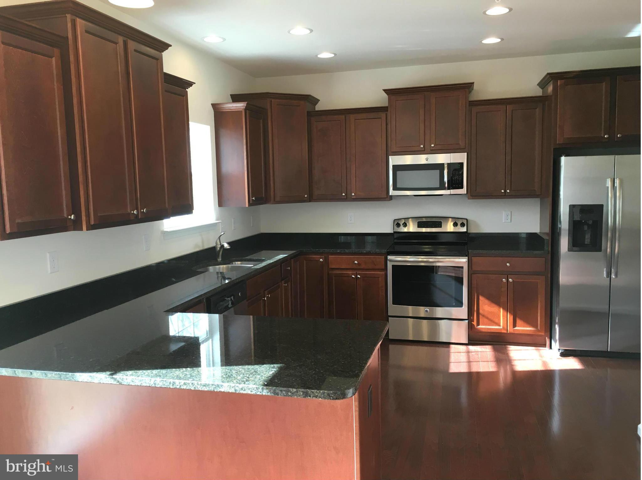 13213 Choptank Road Baltimore, MD 21220 - Photo 2 of 10 a kitchen with stainless steel appliances granite countertop a stove a sink and a microwave