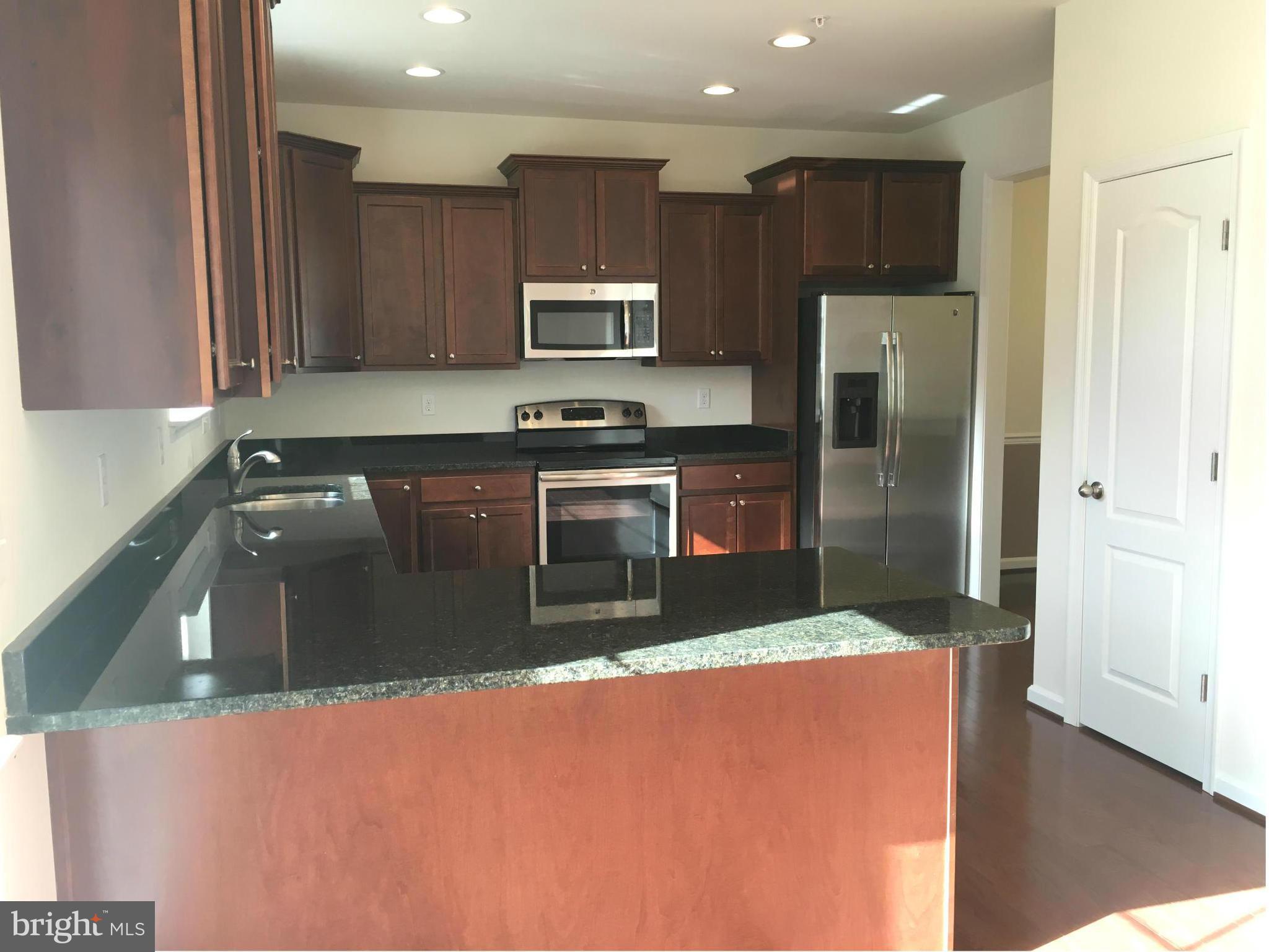 13213 Choptank Road Baltimore, MD 21220 - Photo 3 of 10 a kitchen with stainless steel appliances granite countertop a refrigerator a sink a stove a microwave and island