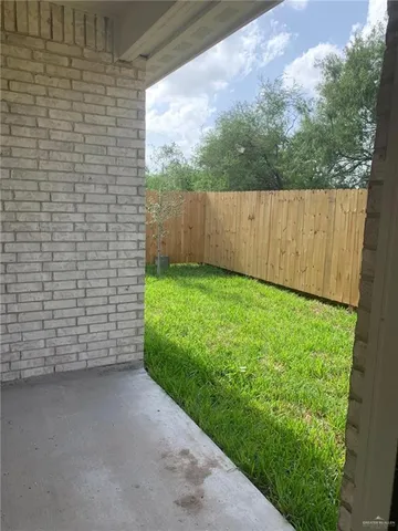 a view of backyard with potted plants and wooden fence