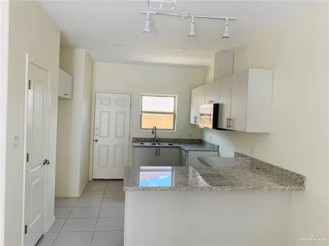 a large kitchen with a stove a refrigerator and a sink