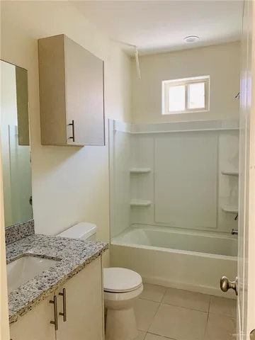 a bathroom with a granite countertop sink a toilet and shower
