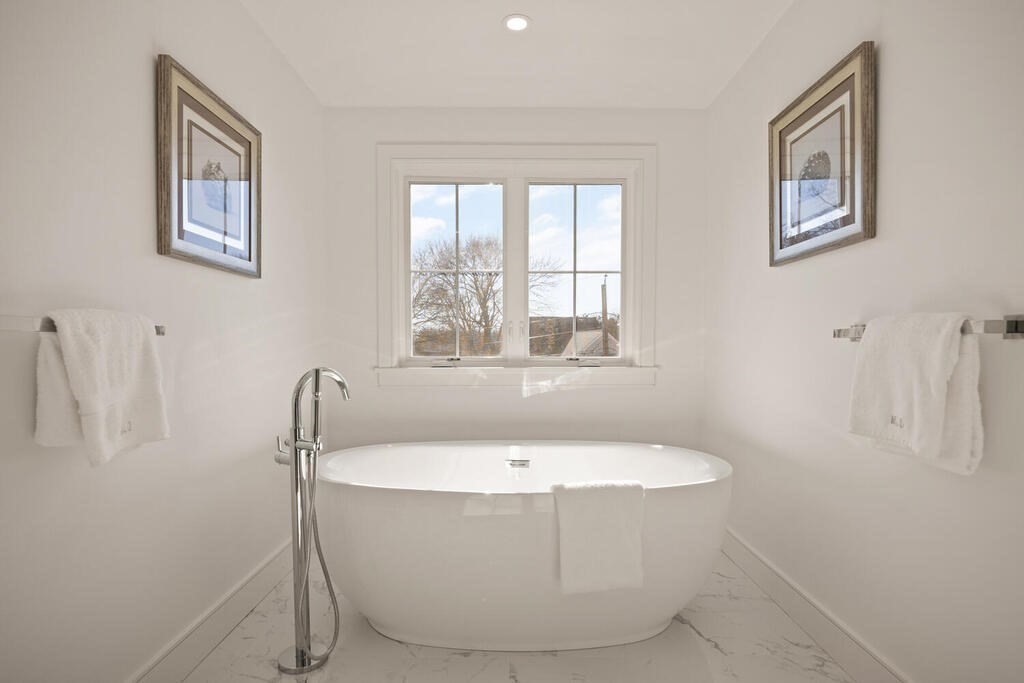 40 Bridge Street Lexington, MA 02421 - Photo 28 of 42 a white bath tub sitting in a bathroom next to a window
