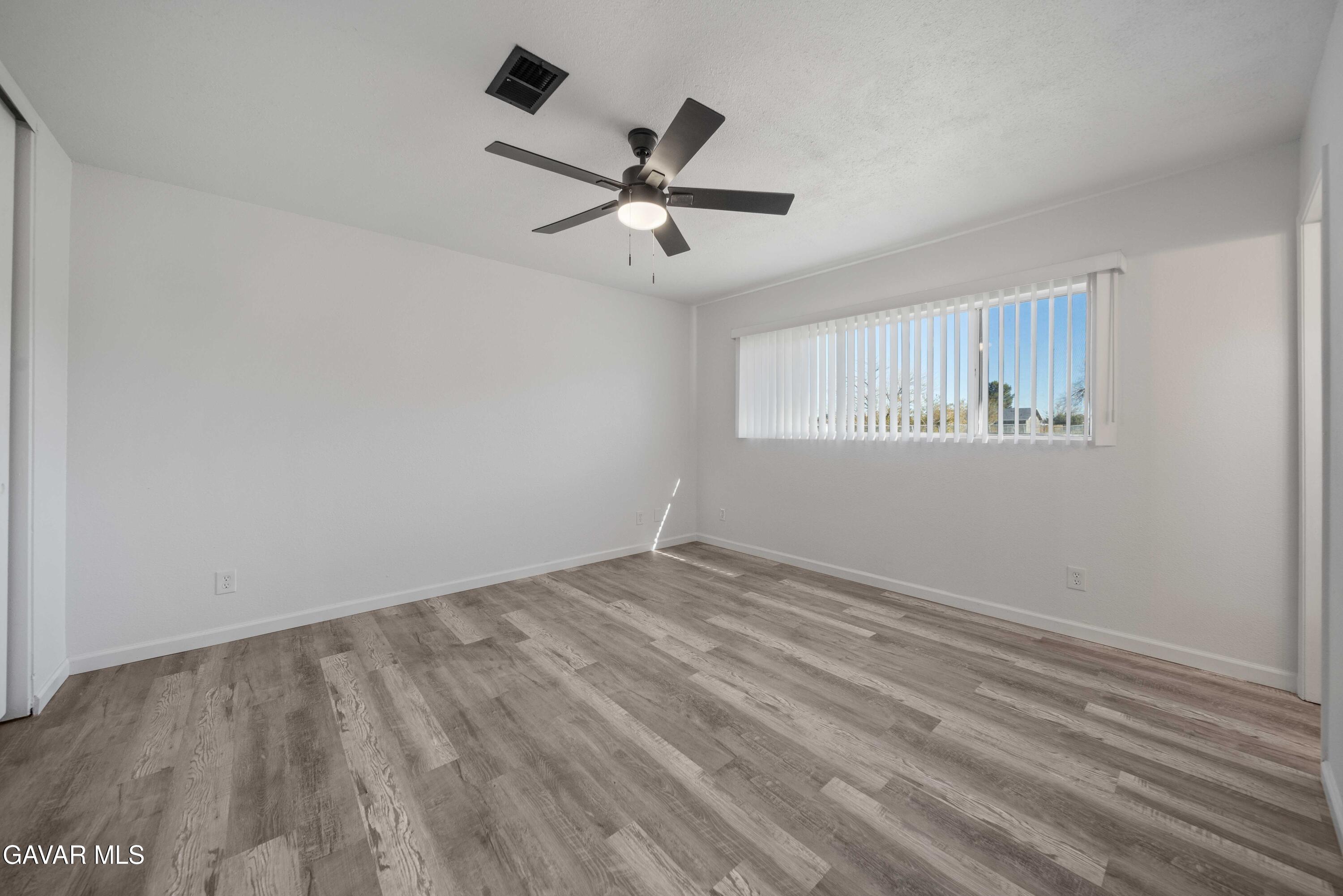 40054 Ridgemist Street Palmdale, CA 93591 - Photo 13 of 21 wooden floor in an empty room with a window