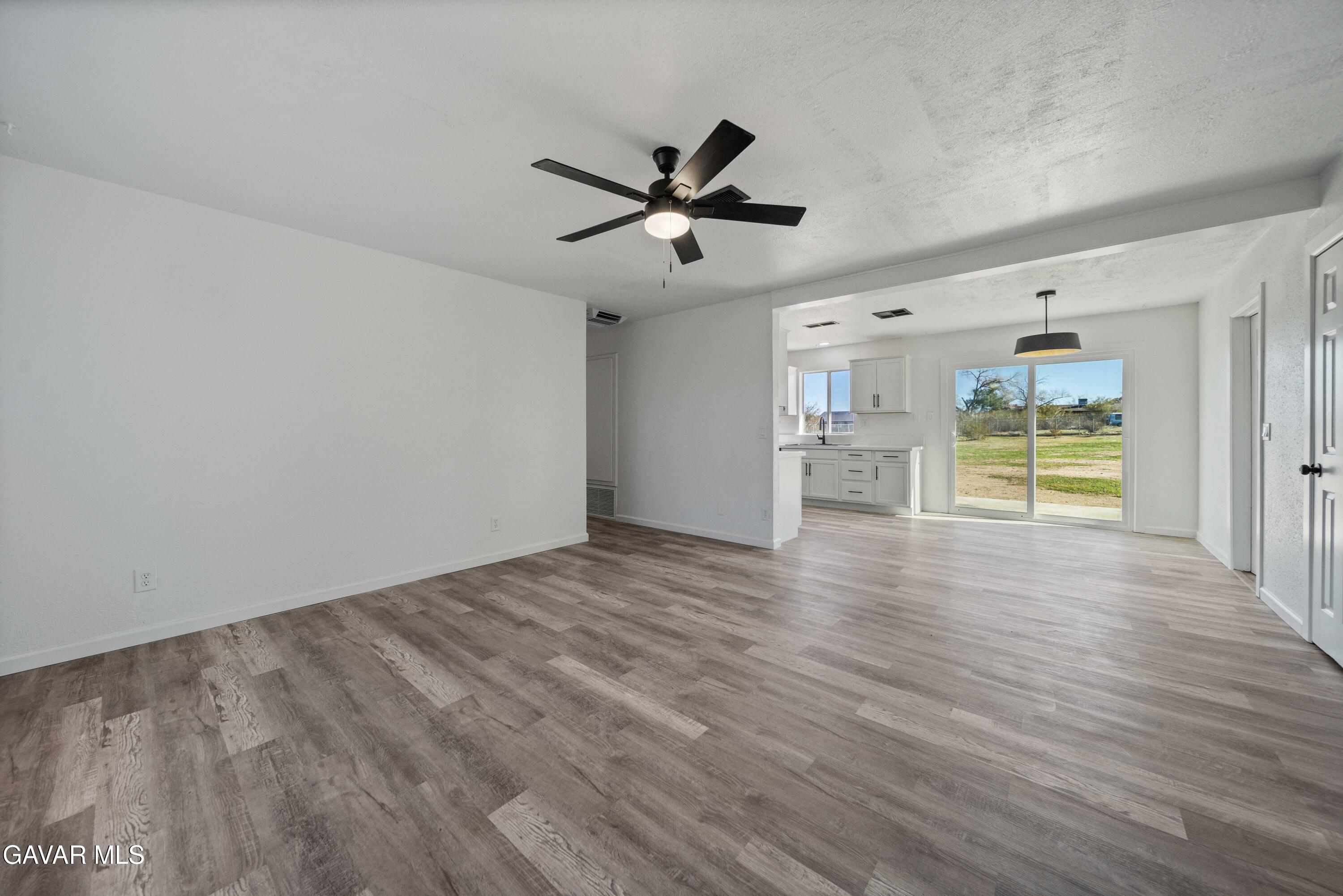 40054 Ridgemist Street Palmdale, CA 93591 - Photo 4 of 21 a view of an empty room with a window and wooden floor