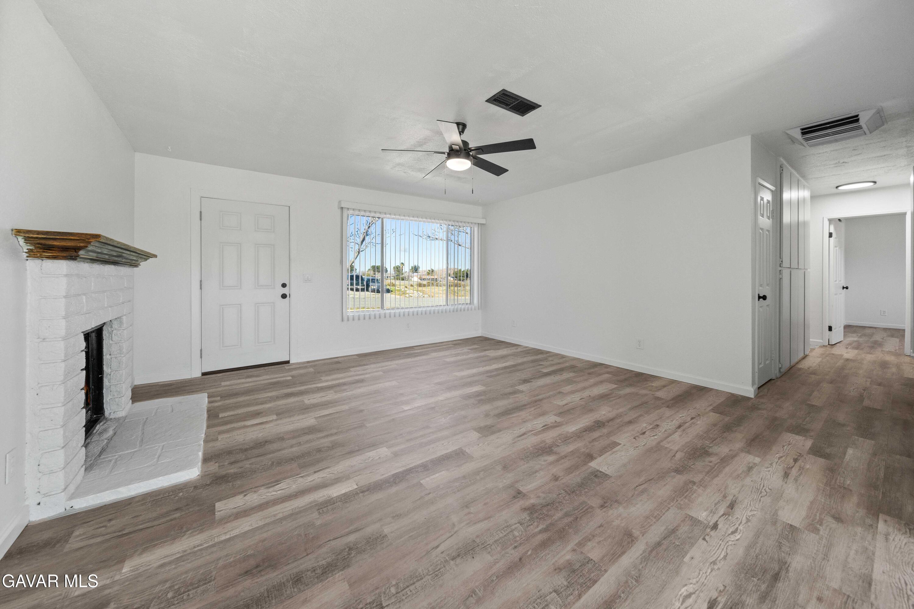 40054 Ridgemist Street Palmdale, CA 93591 - Photo 6 of 21 wooden floor in an empty room with a fireplace