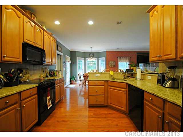 3228 Williams Station Road Matthews, NC 28105 - Photo 10 of 16 a kitchen with stainless steel appliances granite countertop a sink a stove top oven a counter space and cabinets