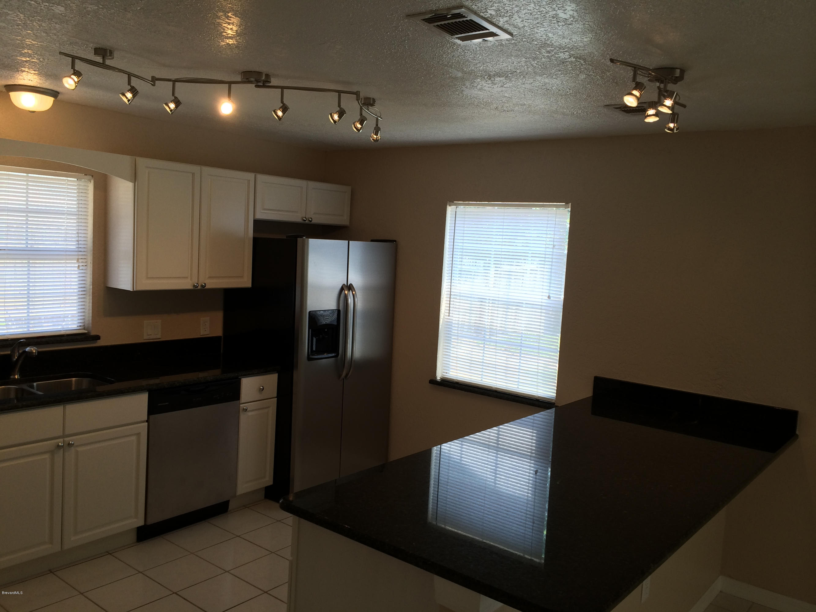 6965 Bryant Road Cocoa, FL 32927 - Photo 3 of 12 a kitchen with stainless steel appliances a refrigerator and a sink