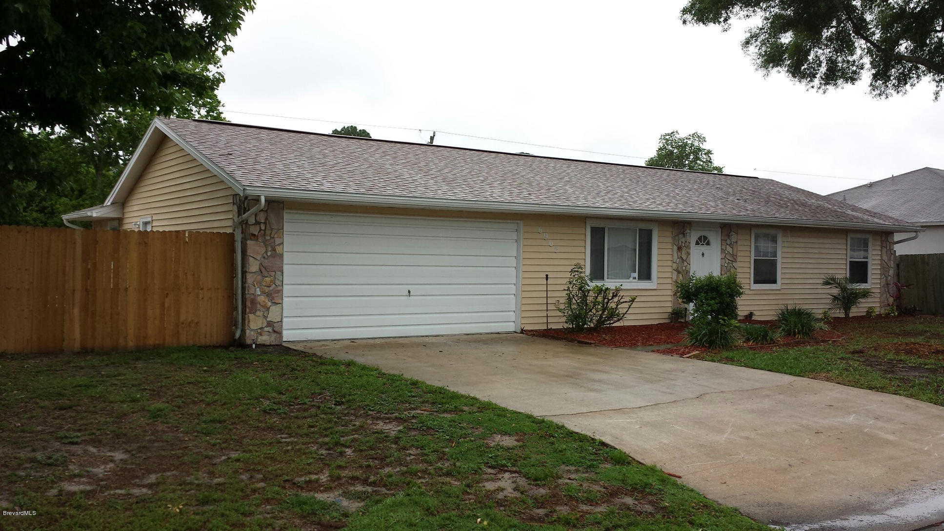 6965 Bryant Road Cocoa, FL 32927 - Photo 10 of 12 a view of a house with a yard and garage