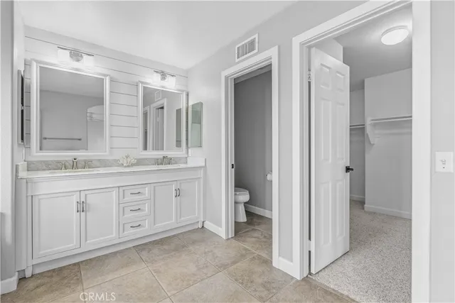a spacious bathroom with a granite countertop sink mirror and toilet
